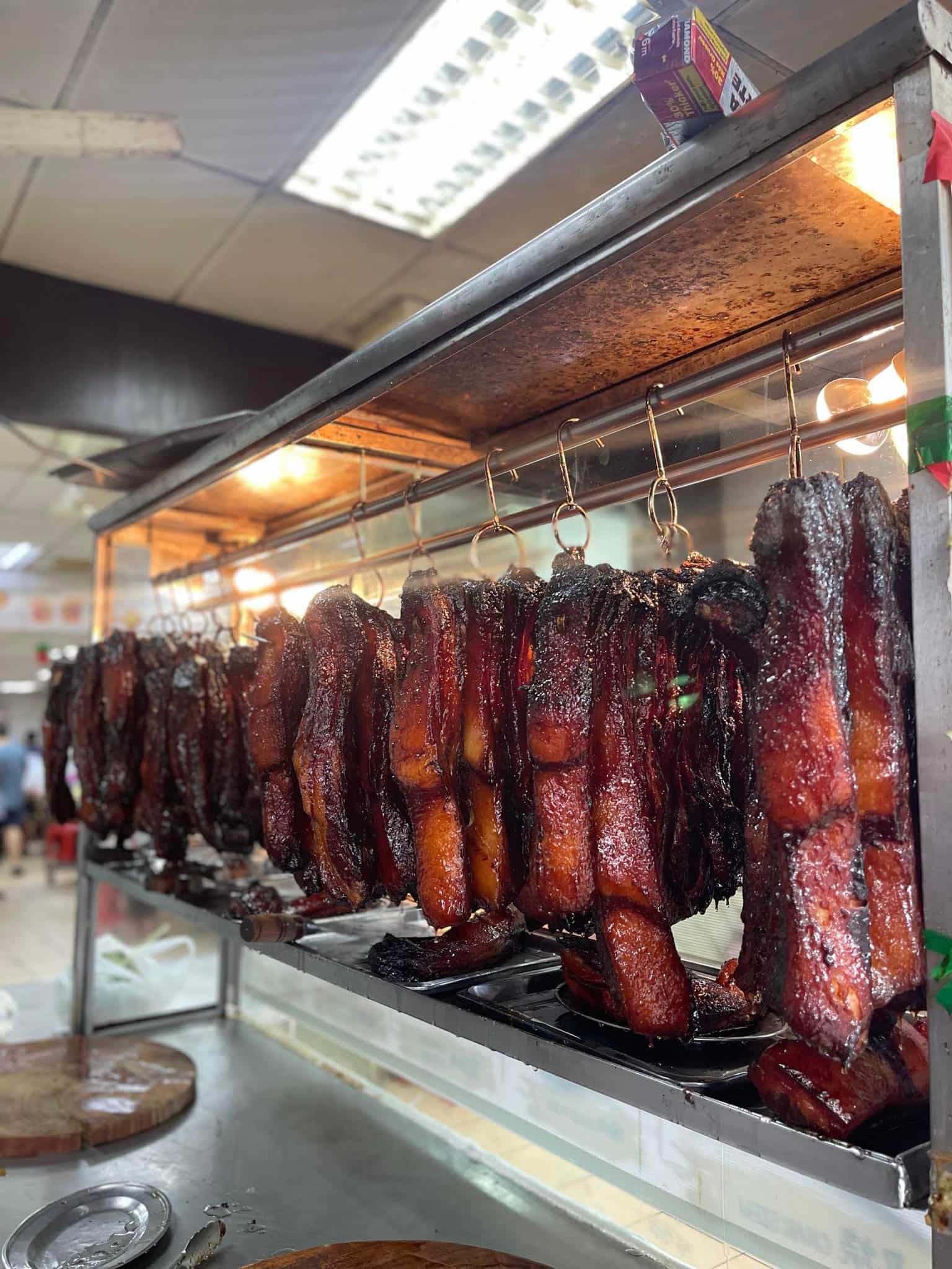 The sticky barbequed pork hanging up after they are cooked