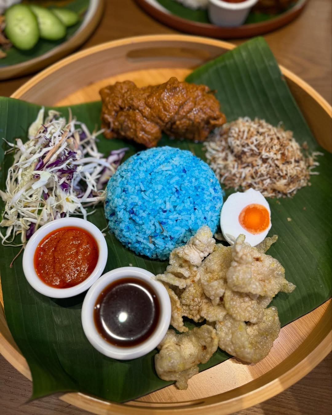 Street vendors in KL have slight variations of this iconic dish, like this nasi lemak done with blue rice and pork crackling and curry