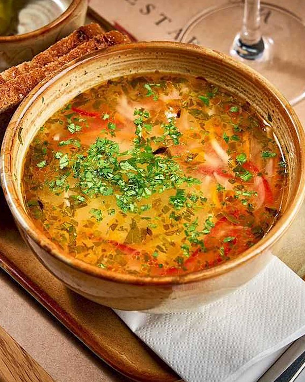 a brown bowl containing zeema chicken soup a traditional food in moldova 