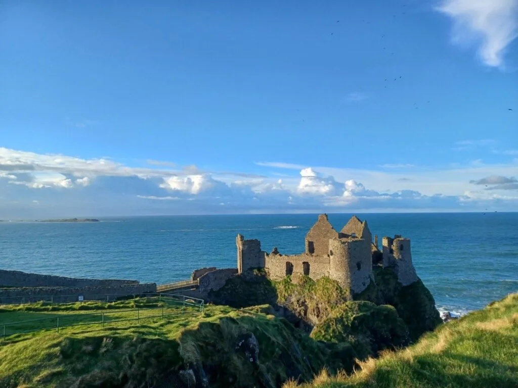 a ruined castle looking out onto the irish sea at dunluce northern ireland