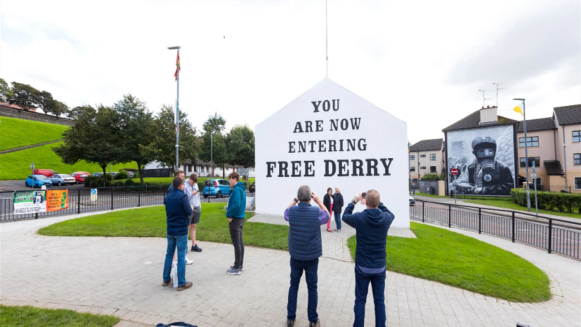 people taking photos of a mural on a building at free derry corner londonderry northern ireland