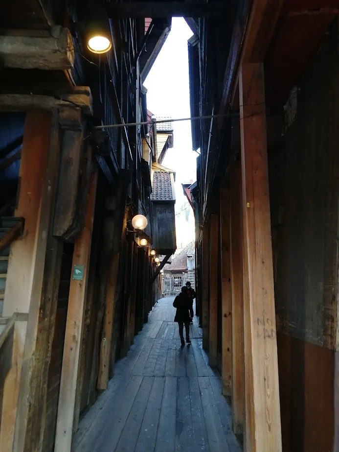 a narrow passageway between wooden houses in bryggen bergen norway