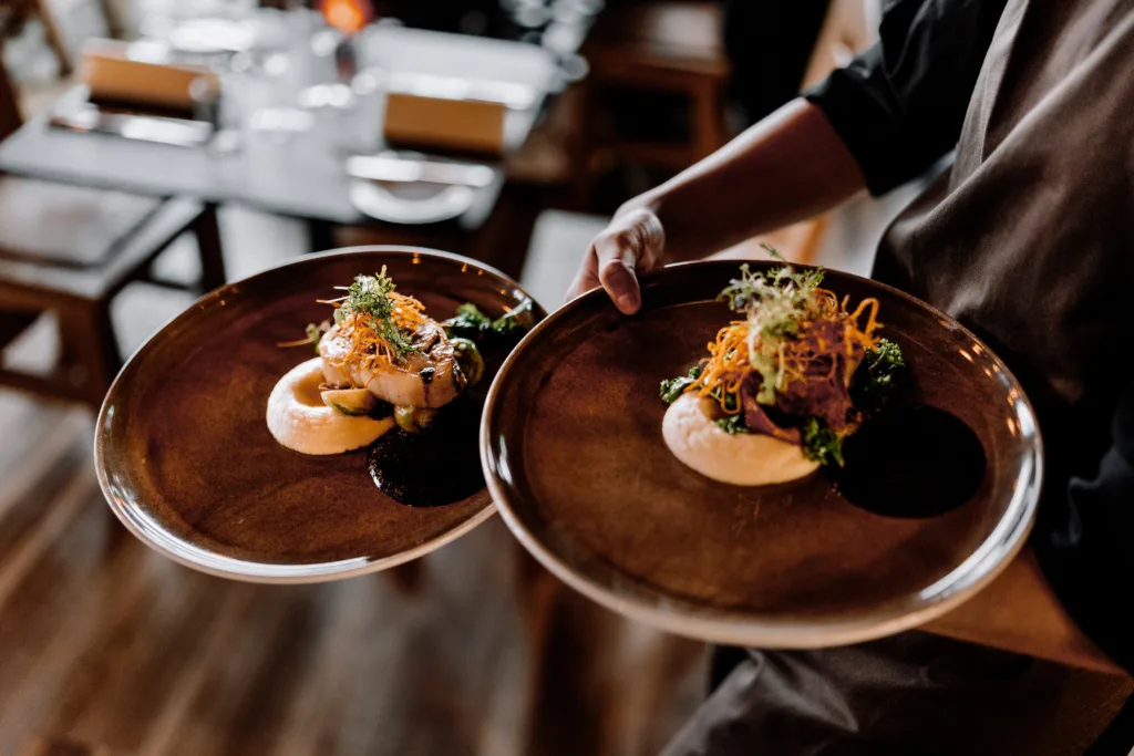 brown plates with meat and seafood dishes at troll restaurant trondheim norway