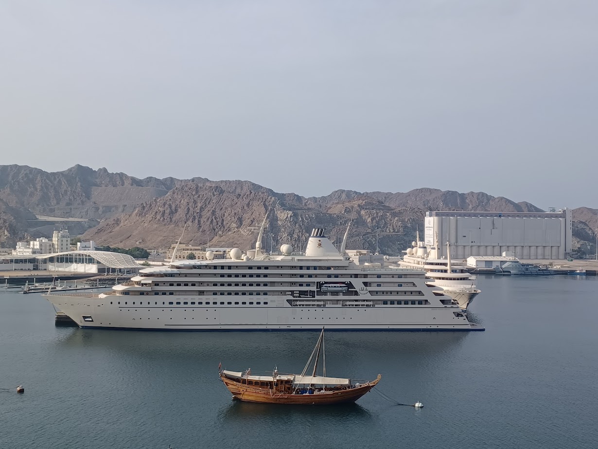 the sultan of oman's luxury motor yacht al said behind a traditional wooden dhow in muttrah harbor muscat oman