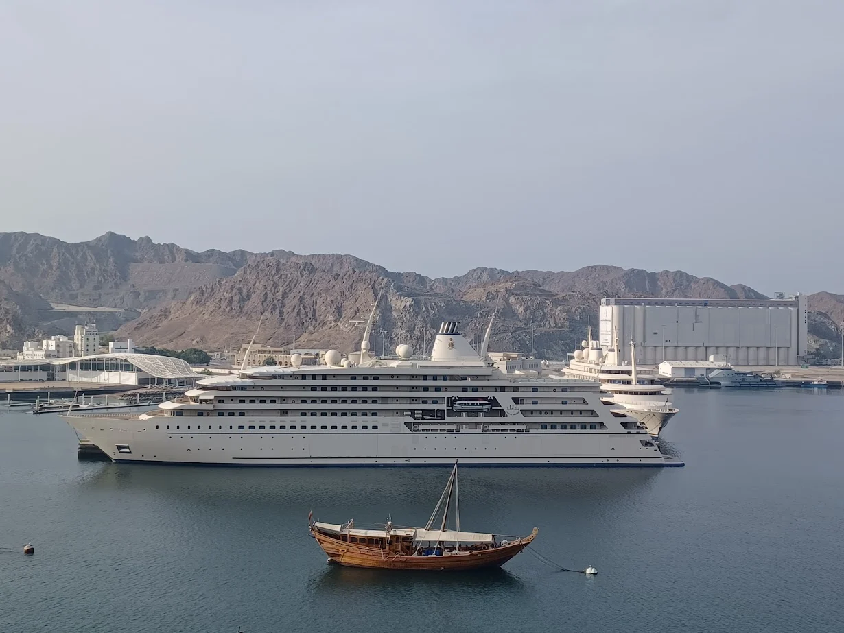 the sultan of oman's luxury motor yacht al said behind a traditional wooden dhow in muttrah harbor muscat oman