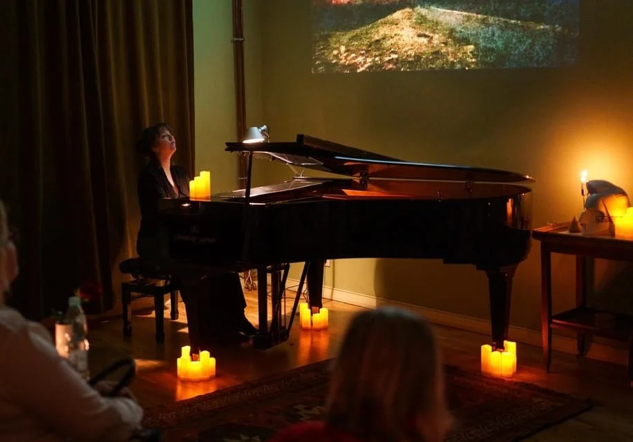 a black piano in a candlelit concert venue in warsaw poland