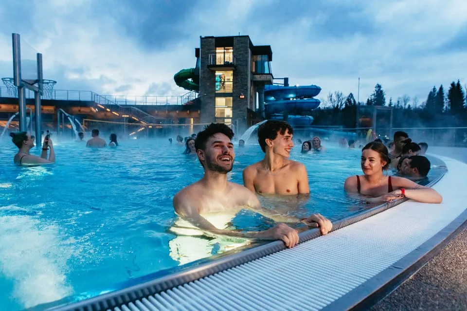 two men and a woman in water at chocholowskie thermal bath near zakopane in the tatra mountains poland