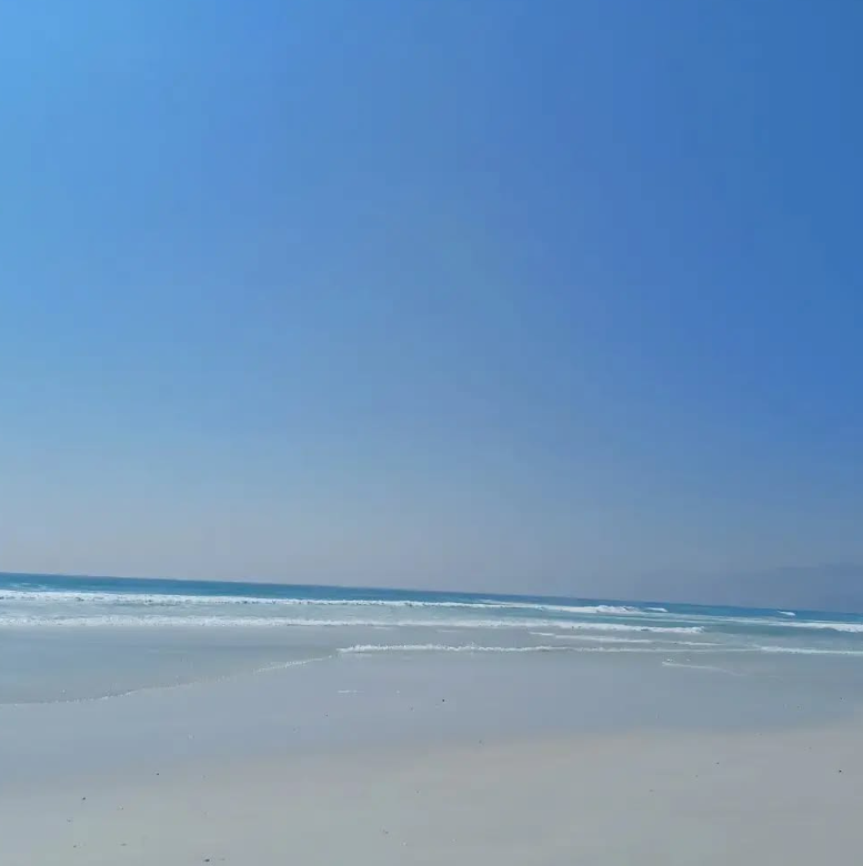 the indian ocean lapping against the white sands of muscat beach in oman