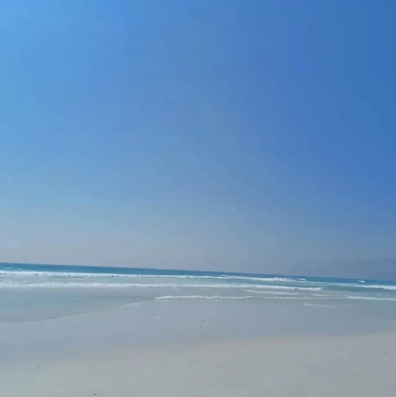 the indian ocean lapping against the white sands of muscat beach in oman