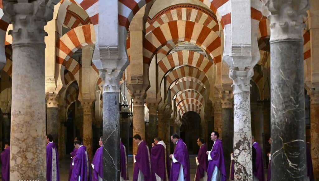 Priests walking through corridoors of the grand Mosque