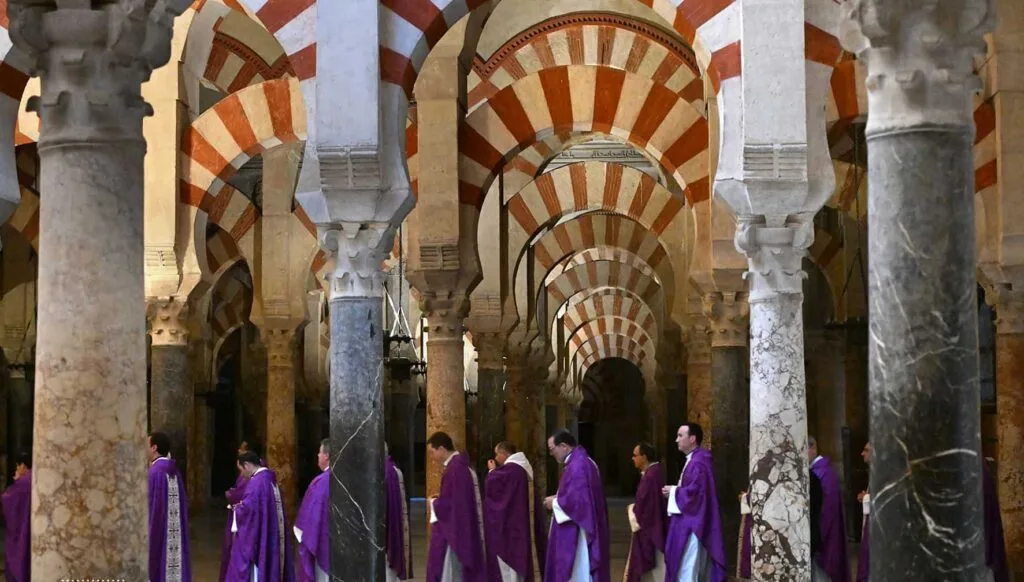 Priests walking through corridoors of the grand Mosque