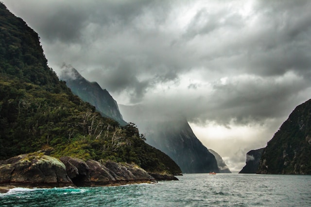 a dramatic dark sky over mountains and a fjord in norway