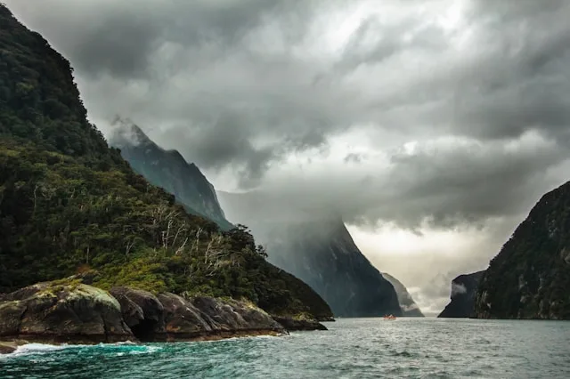 a dramatic dark sky over mountains and a fjord in norway