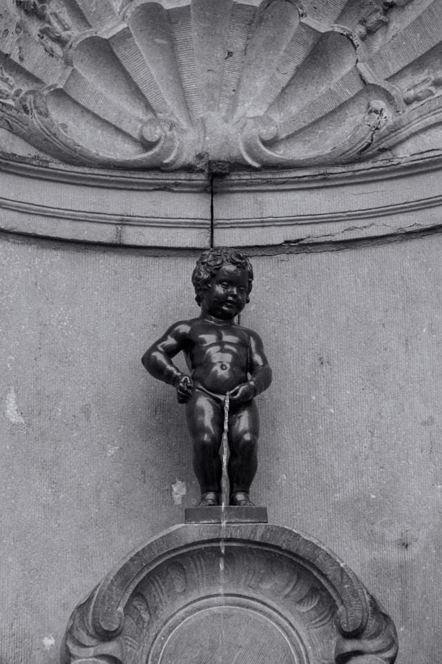 manneken pis is a small bronze fountain statue of a small boy urinating in brussels belgium