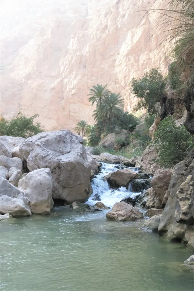 a waterfall leads into a pool in wadi shab oman