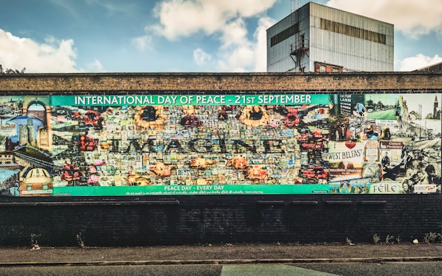 a mural on the peace wall in belfast northern ireland with a high-rise tower block in the background