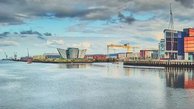the modern building housing titanic belfast next to a yellow harland and wolff crane in belfast port northern ireland