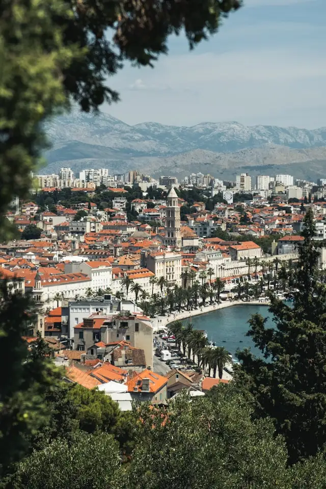 the baroque buildings of split old town in croatia with the bell tower in the background and the adriatic sea in the foreground