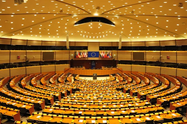 an auditorium with seating and the EU flag at the european parliament in brussels belgium