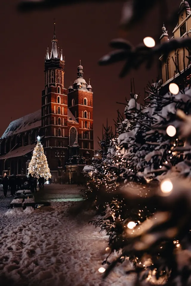 christmas trees and lights in front of a church in the old town of krakow poland