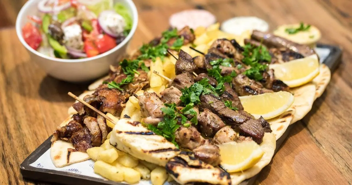a greek mixed grill with a greek feta salad in a bowl at amvrosia greek restaurant in antwerp belgium