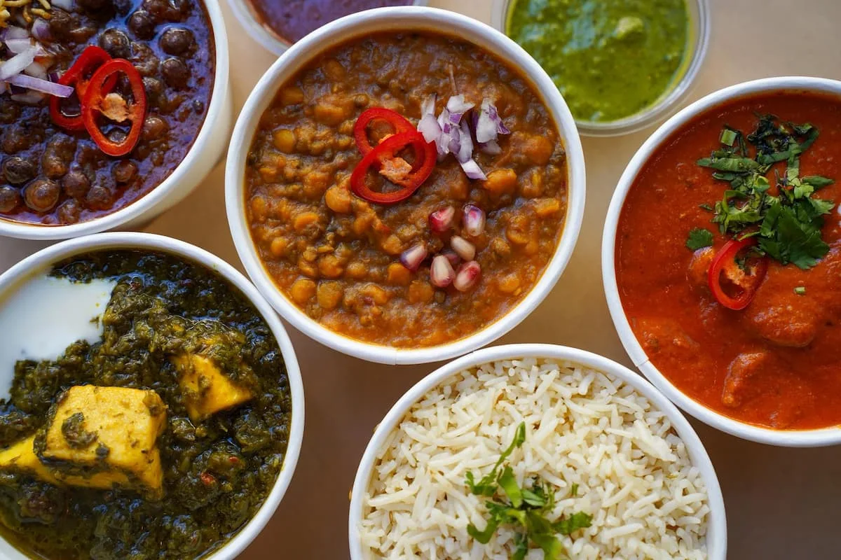 a selection of indian curries and rice in white bowls at curry dhaba one of the best restaurants in antwerp belgium