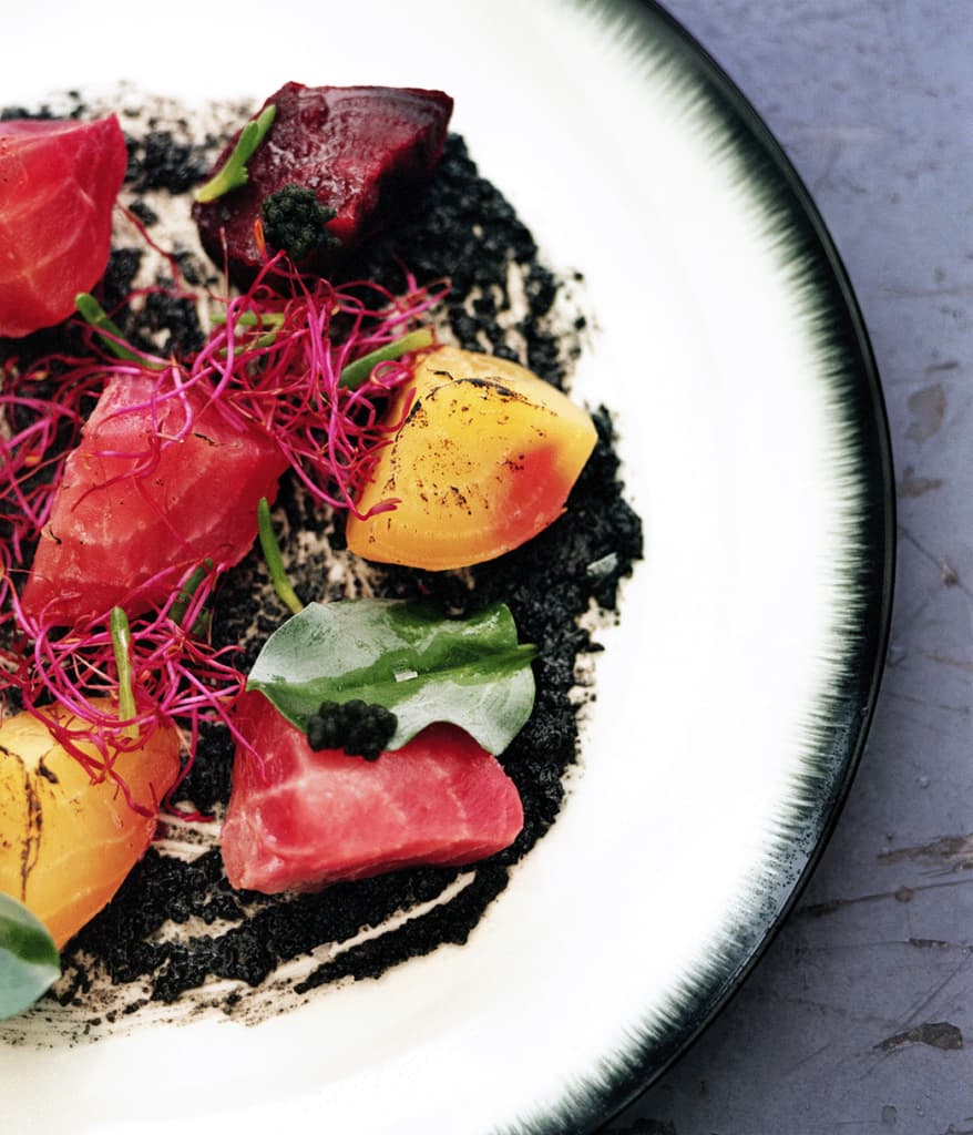a white plate with a black rim containing a colorful salad from and/or vegan restaurant in antwerp belgium