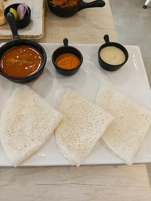 A platter of traditional Goan pancakes with chutneys