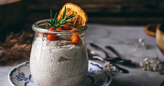 a glass jar on a plate containing kamavaht a traditional estonian dessert