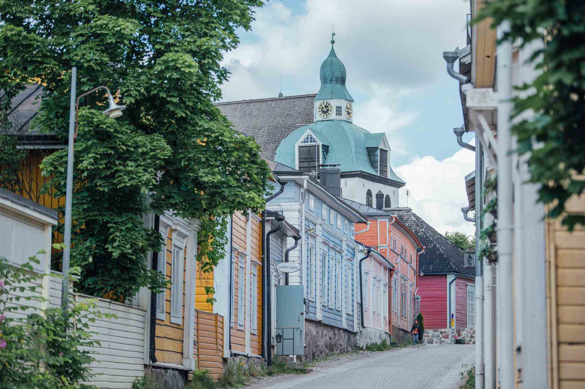 Colorful wooden houses with a church spire in the background