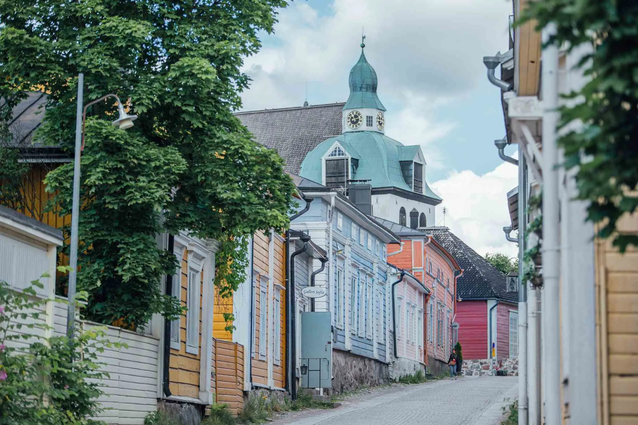 Colorful wooden houses with a church spire in the background