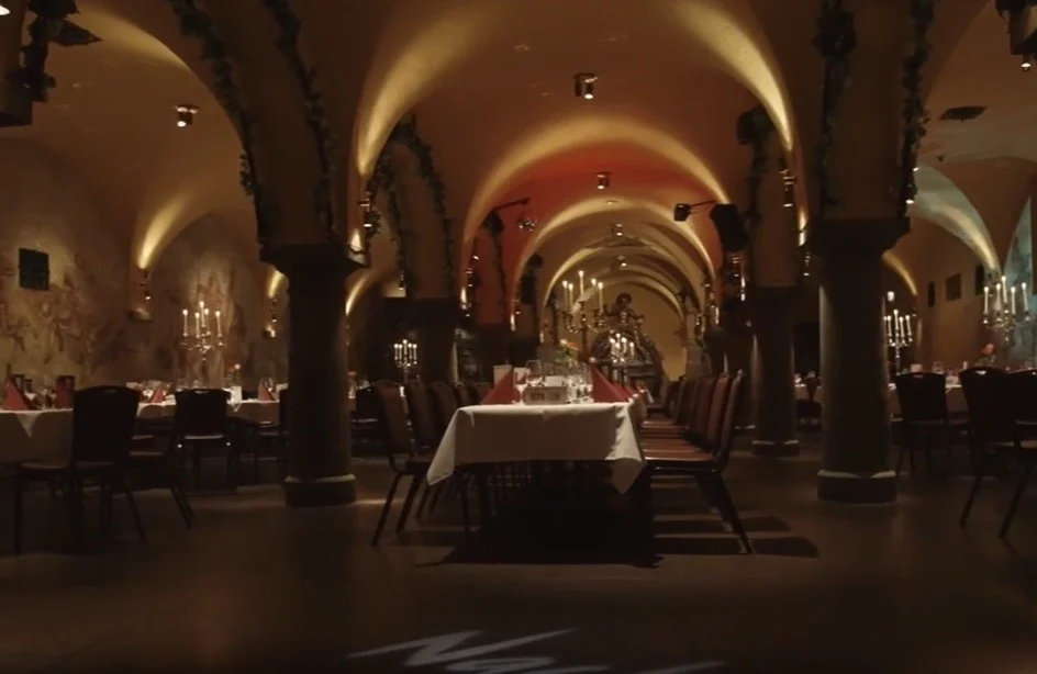 A restaurant table atmospherically lit, under a vaulted ceiling