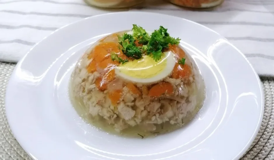 a white plate with auksta gala a gelatinous cold meat dish popular in latvia