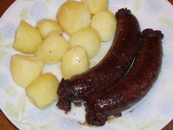 traipen is a luxembourgish blood sausage served on a white plate with boiled potatoes