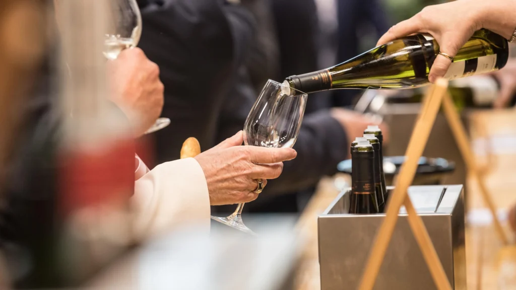 a sommelier pours a glass of wine in luxembourg