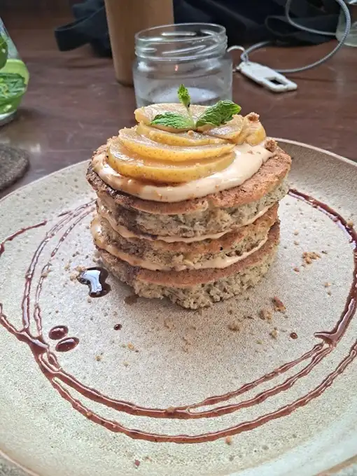 A stack of millet pancakes topped with fruit