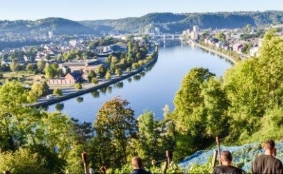 A river flowing through forested hills and past towns in the Ardennen