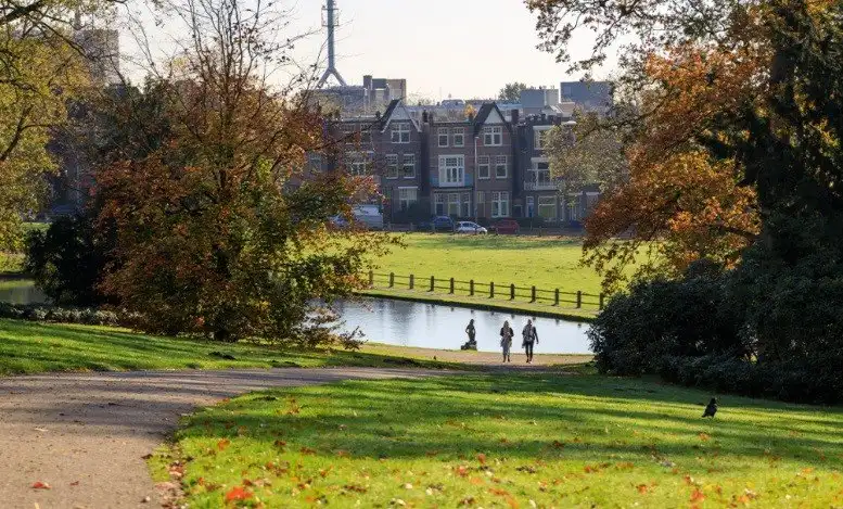 A green park and a lake with Arnhem in the background
