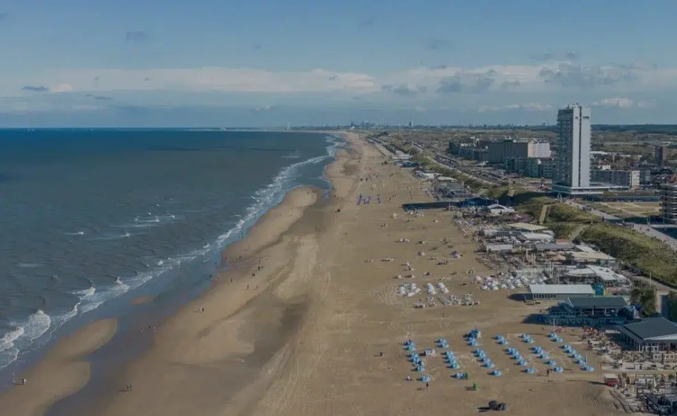 A vast, sandy beach with a bordering city