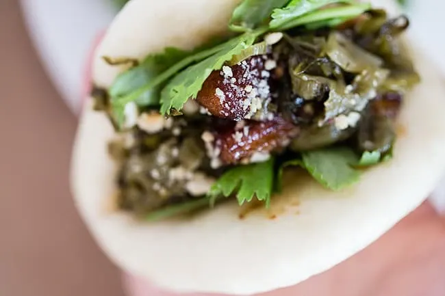 Pickled veg, pork, cilantro inside a gua bao