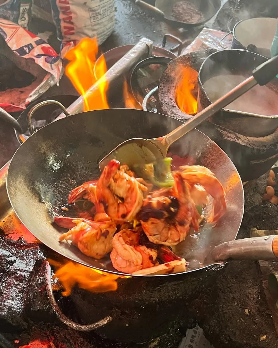 Street food being cooked in a classic wok over the flame