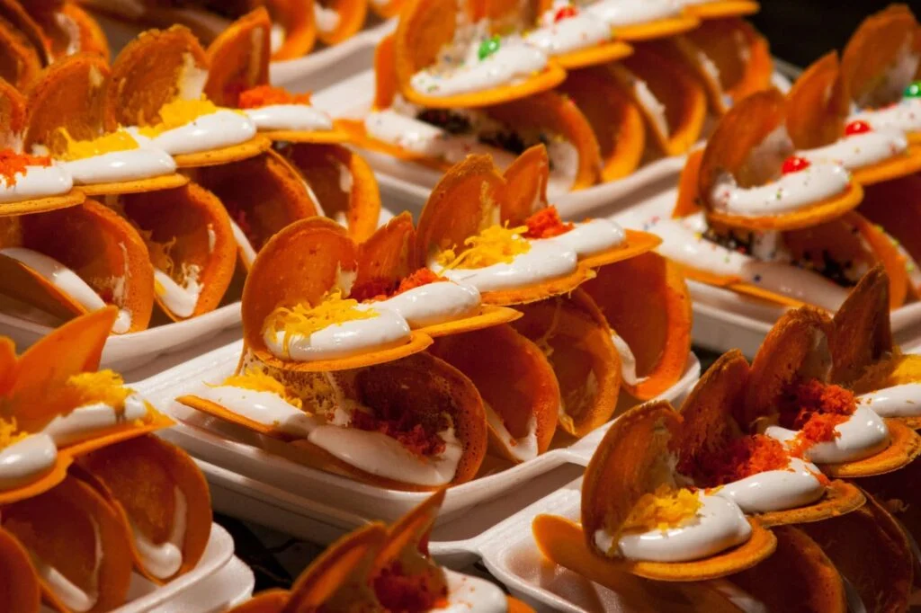 A selection kanom, topped with coconut and some with savory toppings