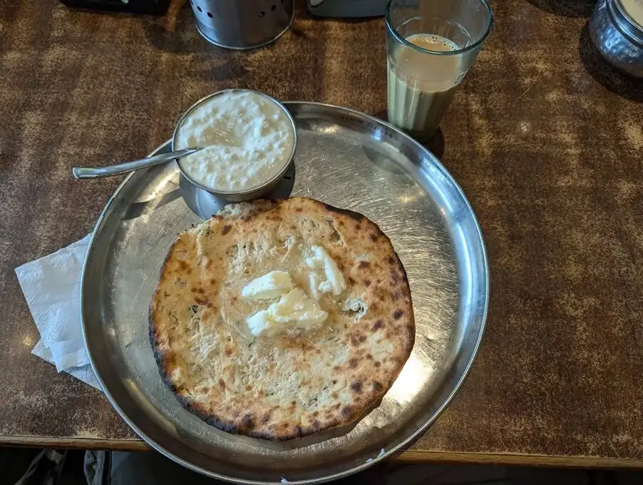 Metal thali plate containing aloo pharatha, a popular Indian breakfast food