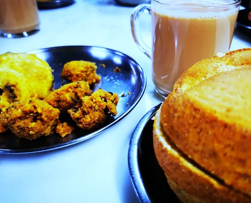 Plate of fritters next to a cup of tea