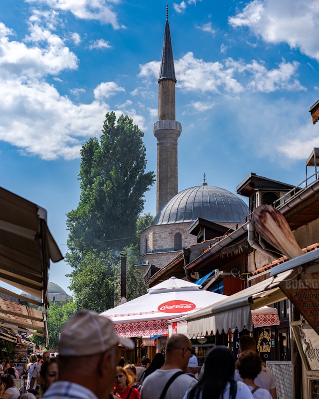 the minaret of the emperor's mosque rises above a market in sarajevo bosnia