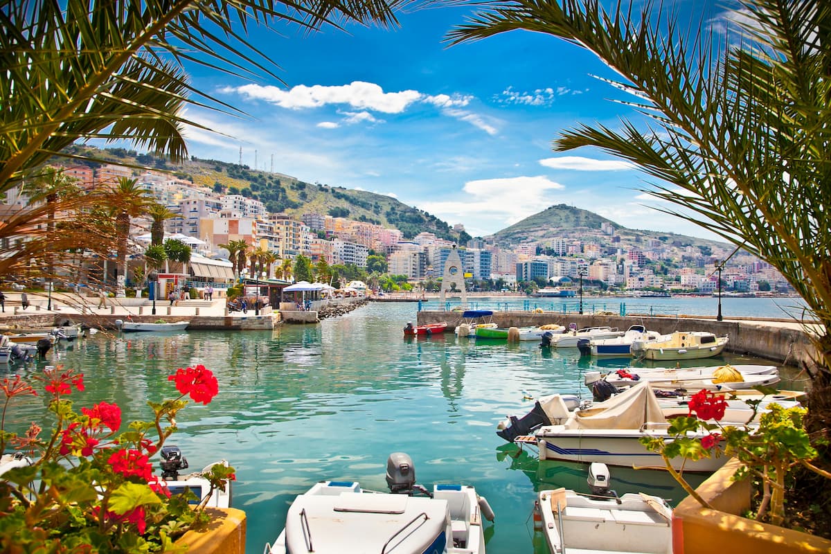 rowing boats moored in sarande harbor albania with flowers in the foreground
