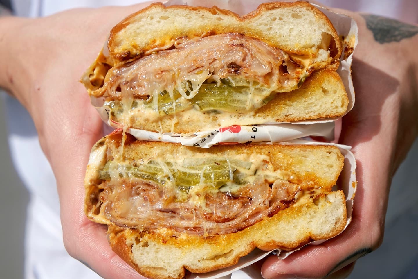 mortadella, provolone, house pickles, and mustard on a soft potato roll