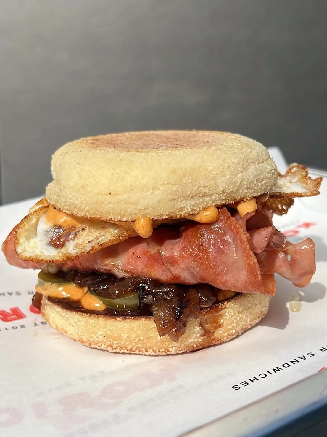 English muffin with bacon, cheese, onions