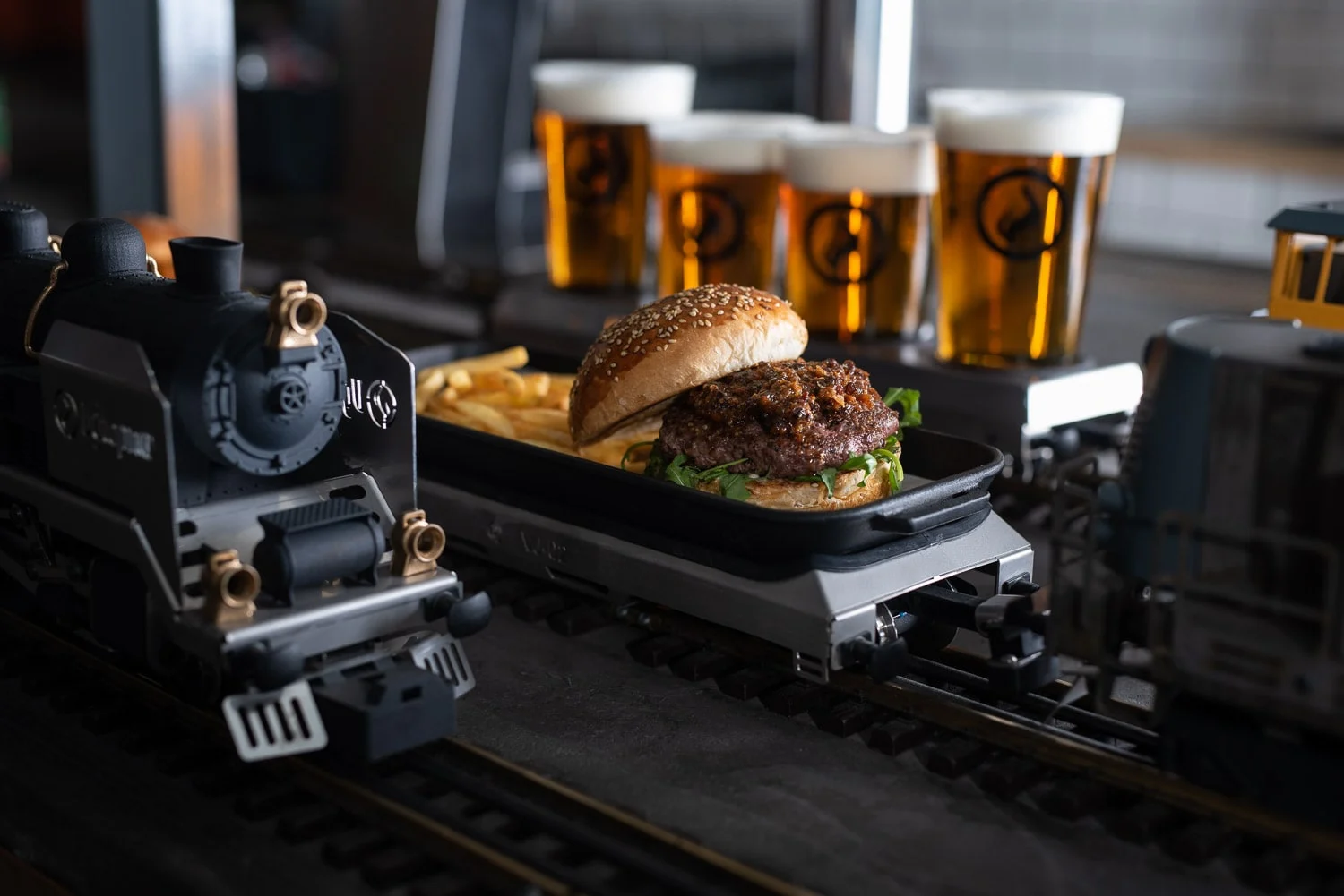 a model locomotive with pints of beer and a burger in the background at vytopna restaurant near wenceslas square in prague czech republic