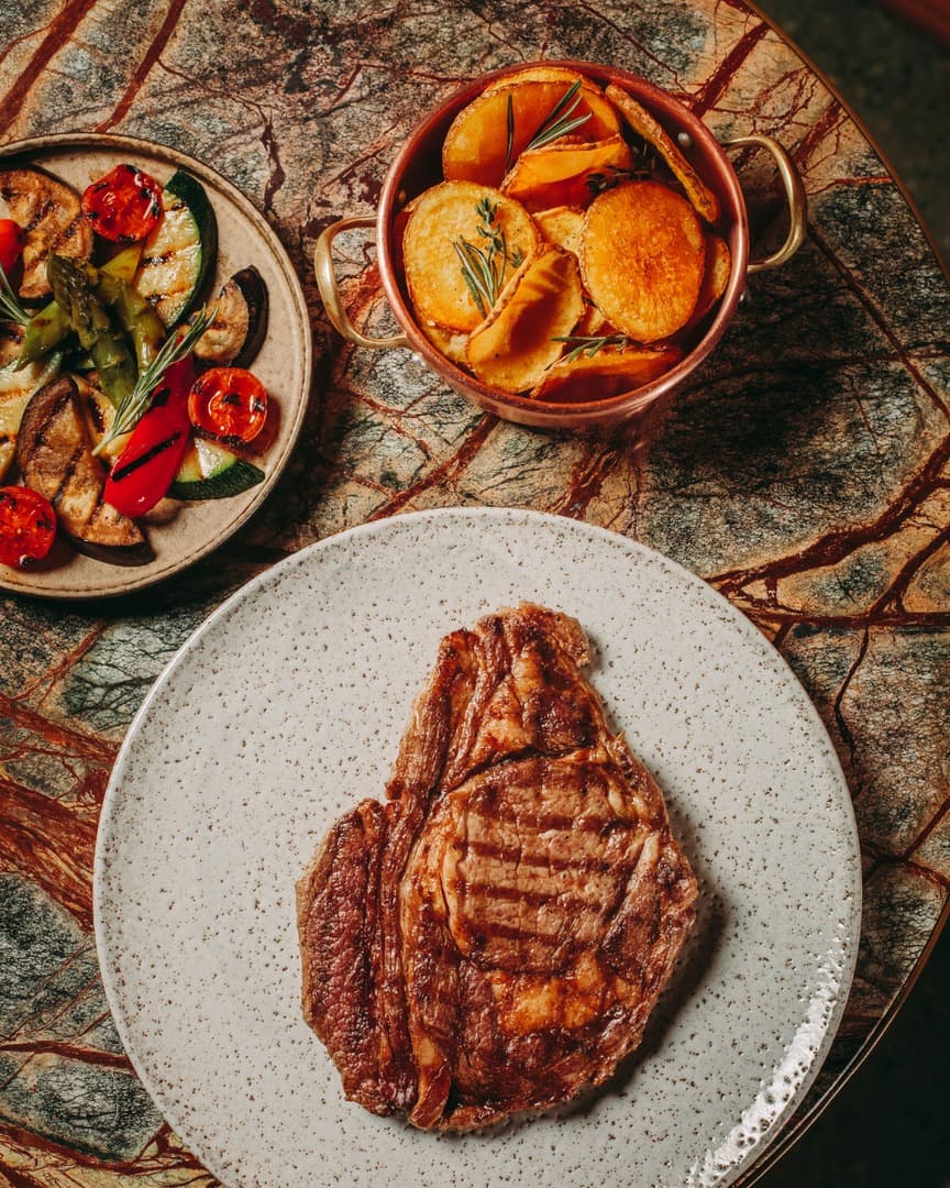 a steak with potatoes and grilled vegetables from real by casa da calcada porto portugal